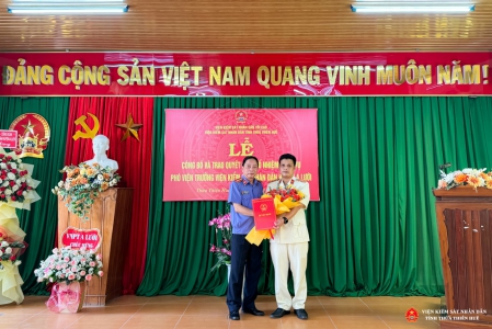 Đồng chí Trần Nhơn Vượng - Uỷ viên BCS Đảng, Bí thư Đảng uỷ, Phó Viện trưởng VKSND tỉnh Thừa Thiên Huế trao quyết định và tặng hoa chúc mừng đồng chí Trương Công Khanh