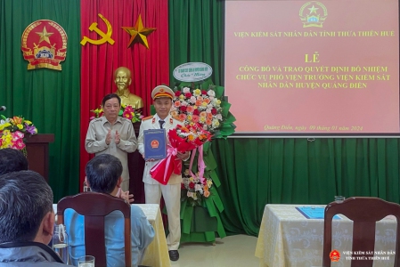 Đồng chí Trần Nhơn Vượng - Uỷ viên BCS Đảng, Bí thư Đảng uỷ, Phó Viện trưởng VKSND tỉnh Thừa Thiên Huế trao quyết định và tặng hoa chúc mừng đồng chí Đặng Văn Minh.