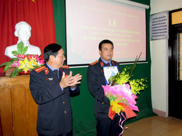 Đ/c Trần Nhơn Vượng, Phó Viện trưởng Viện KSND tỉnh trao quyết định và tặng hoa chúc mừng đ/c Trần Tiến Dũng