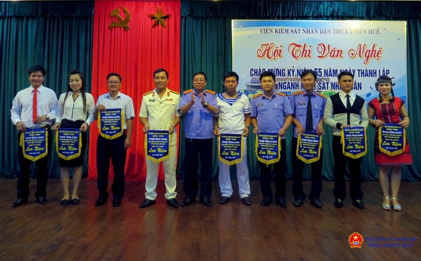 Đồng chí Trần Nhơn Vượng - Phó Viện trưởng Viện KSND tỉnh trao cờ lưu niệm cho các đơn vị tham gia.