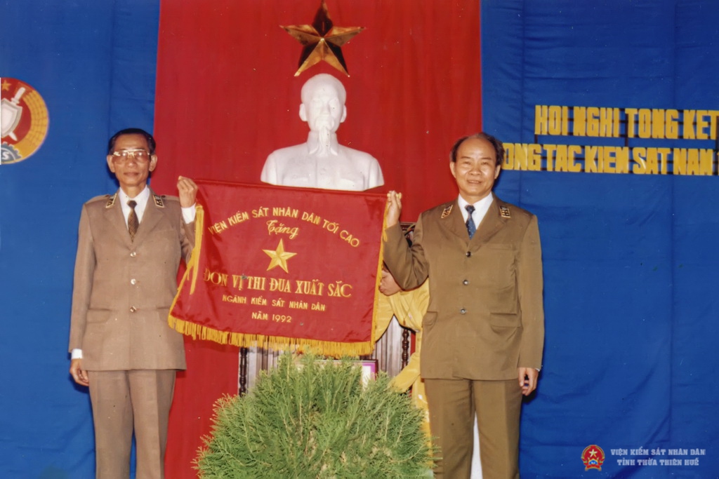 Đồng chí Nguyễn Văn Thìn - Phó Viện trưởng Viện KSND tối cao trao Cờ thi đua xuất sắc cho đồng chí Trần Viết Hường Viện trưởng VKSND Thừa Thiên Huế (giai đoạn 1983 - 1994)