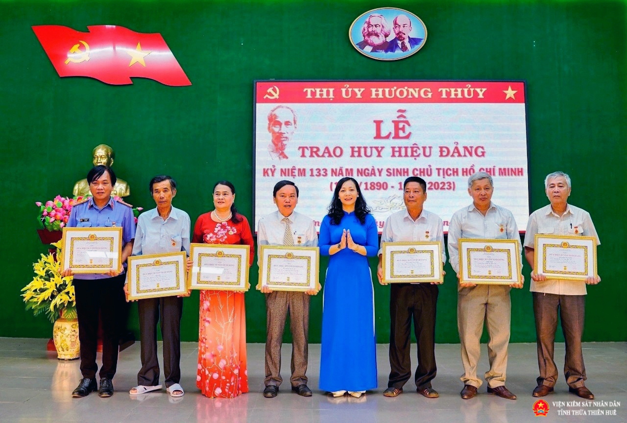 Trưởng Ban tổ chức Thị ủy trao tặng Huy hiệu 30 năm tuổi Đảng cho đồng chí Lê Ngọc Linh (ngoài cùng bên trái) và các đồng chí thuộc Đảng bộ thị xã